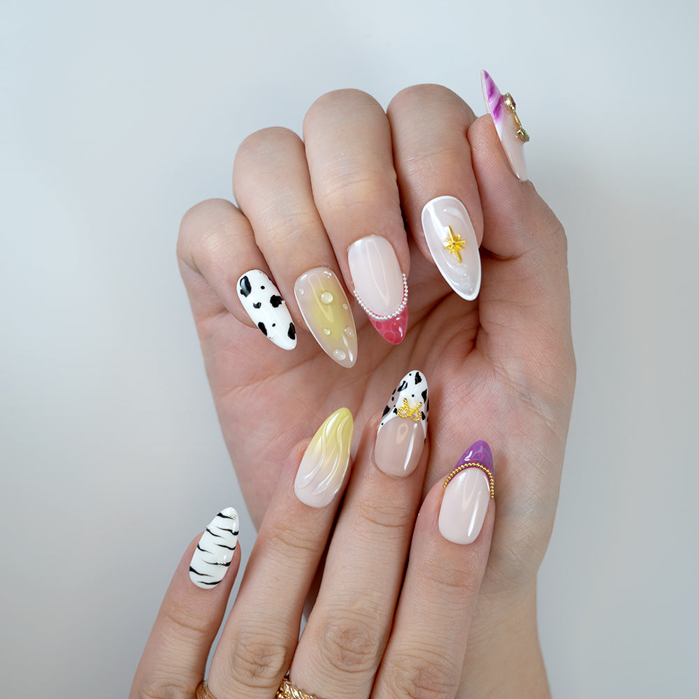 Handmade medium almond press-on nails with mixed patterns, glossy finish and unique charms