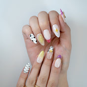 Handmade medium almond press-on nails with mixed patterns, glossy finish and unique charms