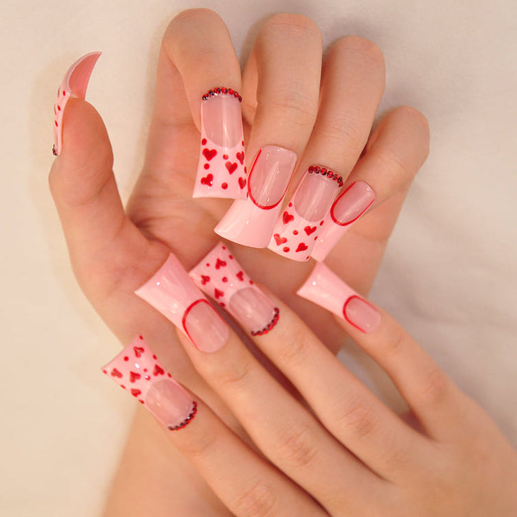 Romantic pink nails with red heart art, square tips, and festive style