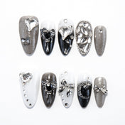Black, white, and grey press-on nails with silver rhinestones and 3D bows