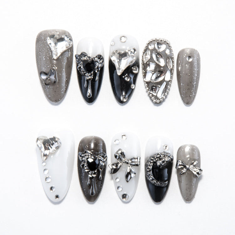 Black, white, and grey press-on nails with silver rhinestones and 3D bows