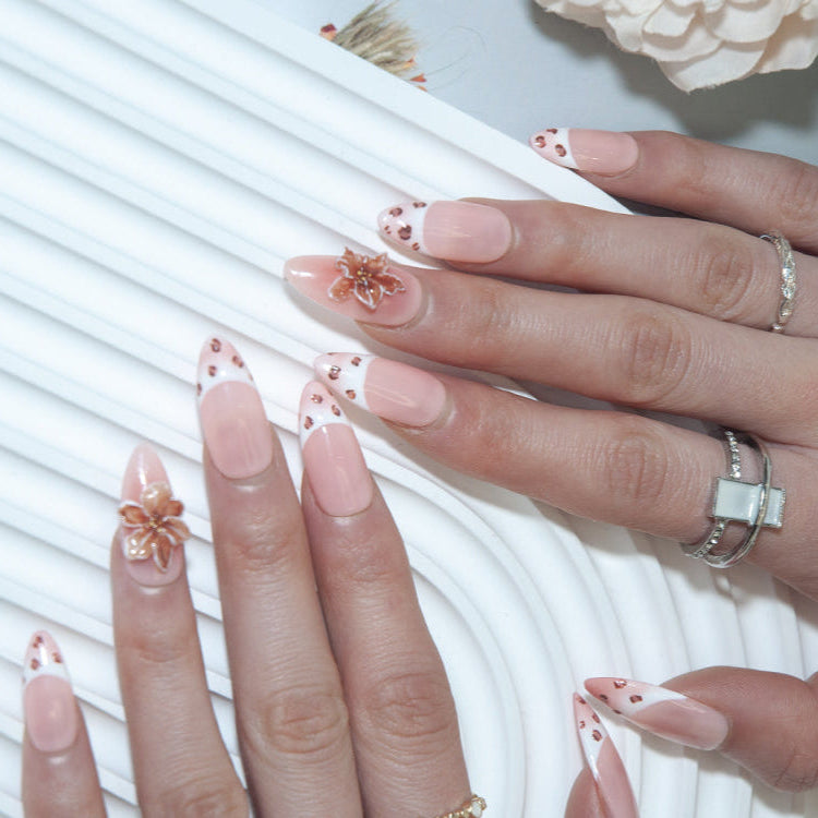 Elegant press-on nails with nude base, leopard tips, and 3D flower