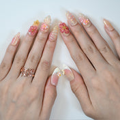 Romantic floral press-on nails with pastel petals, pearls, and glitter ombre