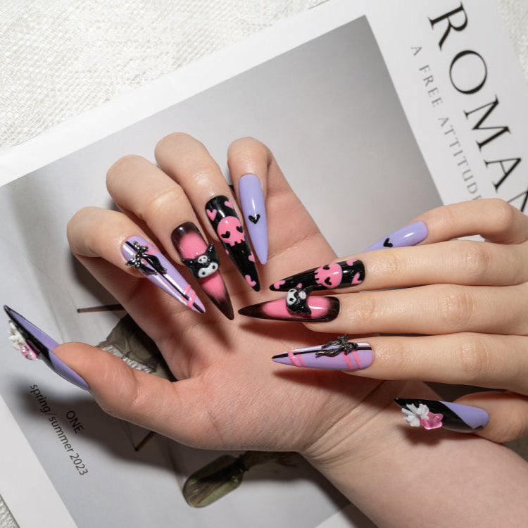 Handmade purple nails with pink skull patterns, striped accents, and character nail art