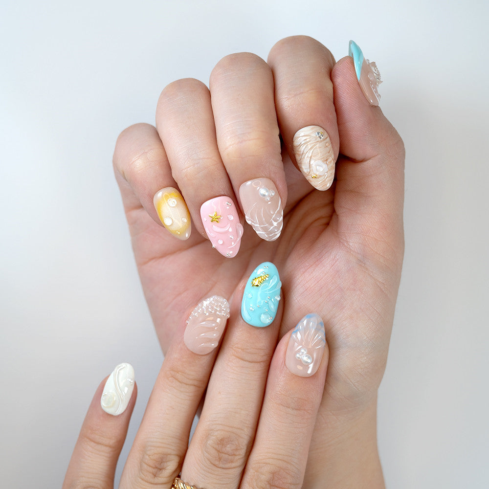 Medium almond nails with pearlescent shine, pastel gradients, seashell textures and starfish