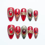 Luxury red press-on nails with vintage gold frames and gemstone accents