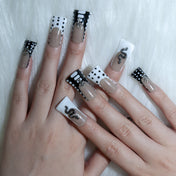 Bold animal theme press-on nails with black-white patterns, polka dots, and snake charm