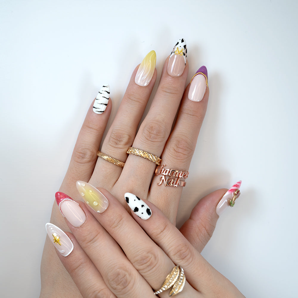 Playful mix-and-match press-on nails with zebra print, cow spots, ombre yellow tips and 3D ice cream charm