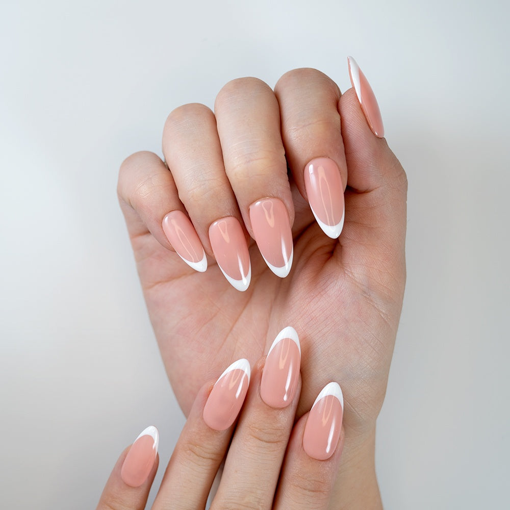 Classic French tip press-on nails in almond shape with nude peach base and glossy finish