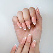 Classic French tip press-on nails in almond shape with nude peach base and glossy finish