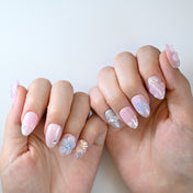 Glittery pink and purple nails with 3D floral and pearl decorations