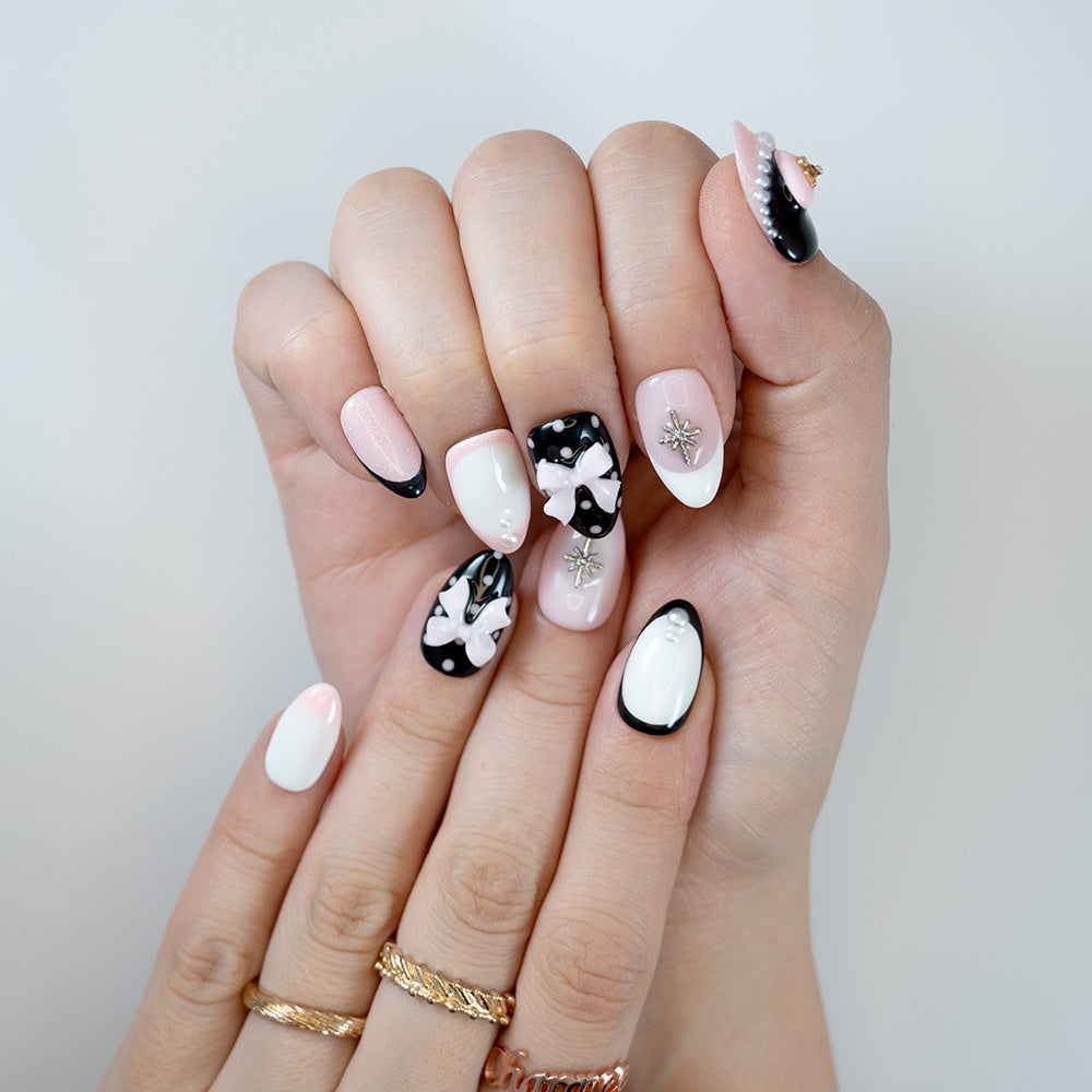 Luxury 3D heart and bow press-on nails in black, white, and pink with pearl embellishments