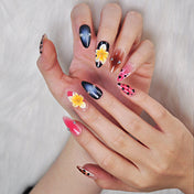 Tropical-inspired nails featuring leopard pattern, nude to pink ombre, and floral centerpiece