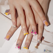 Colorful ombre nails with gemstone accents, water drop design, and glitter