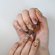 Luxury beach theme nails with brown floral details and shimmering gold edges