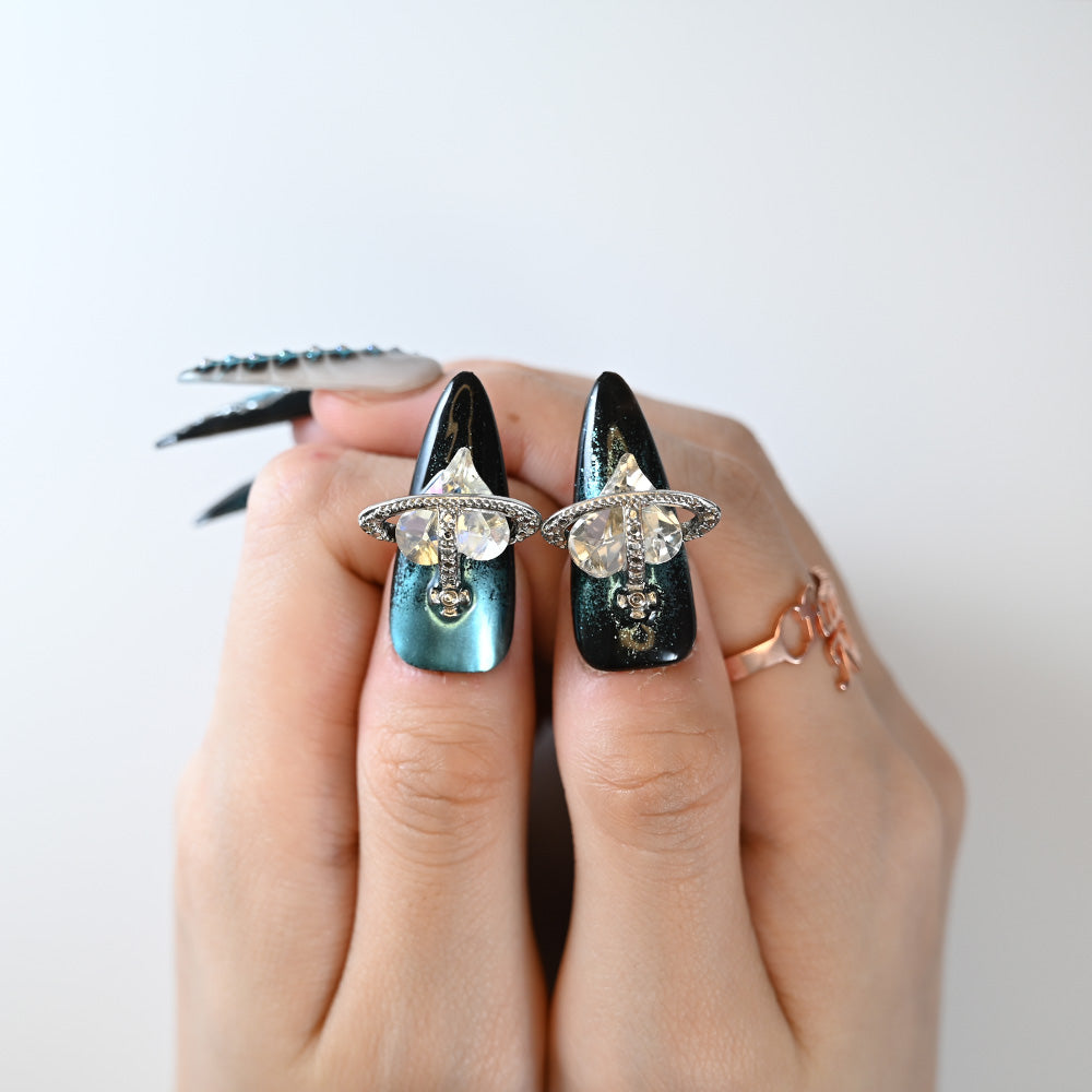 Edgy black stiletto press-on nails featuring teal chrome, rivets, and 3D art