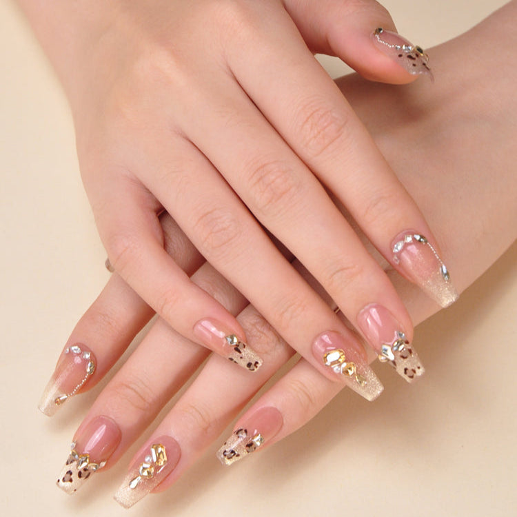 Glam gold and nude press-on nails with leopard spots and rhinestones