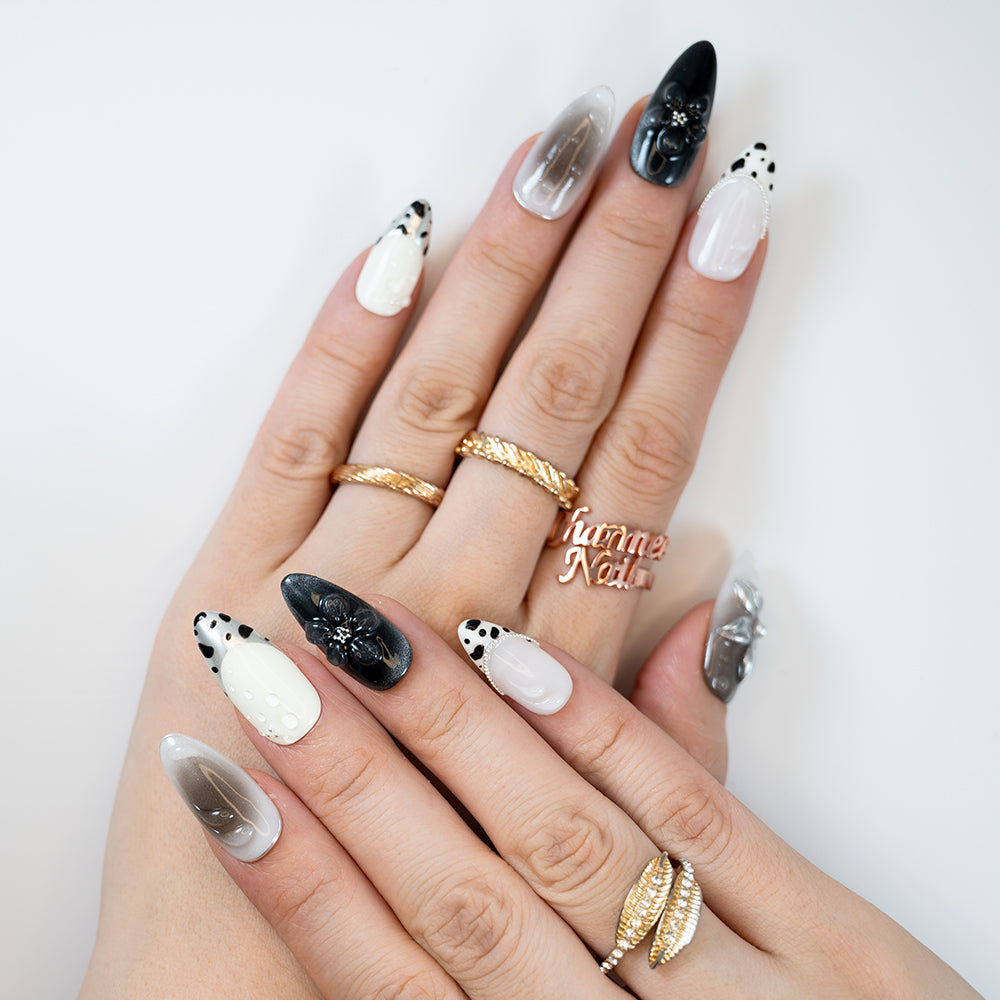 Fashion-forward press on nails with Dalmatian dots, silver shimmer, and floral charm art