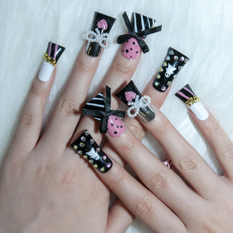 Glam Halloween nails with ghost art, glitter stones, and chic bow decorations