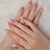 Girly medium nails with nude base, glitter tips, and adorable Hello Kitty details