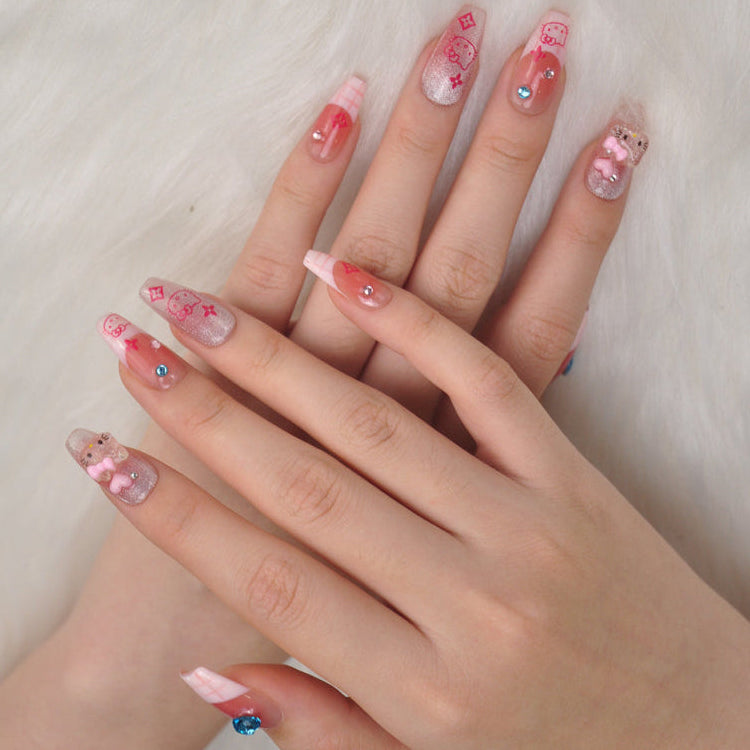 Girly medium nails with nude base, glitter tips, and adorable Hello Kitty details