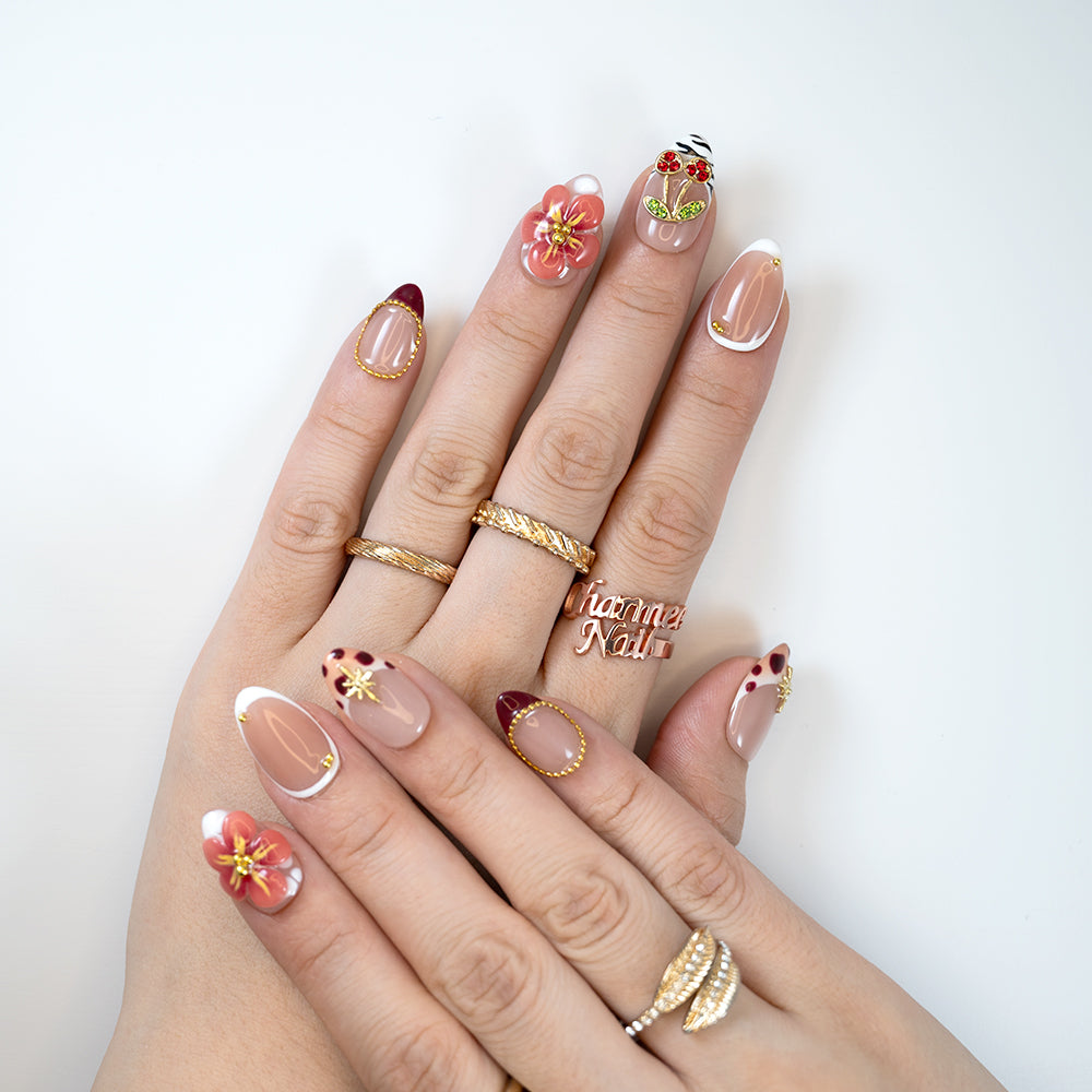 Cute cherry design press-on nails with pink flowers, zebra print, and gold beads