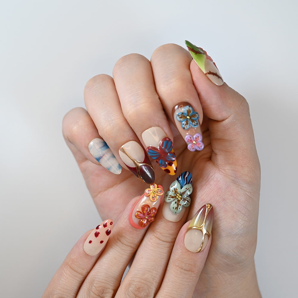 Handmade floral and butterfly nails in bright tropical colors with gradient tips