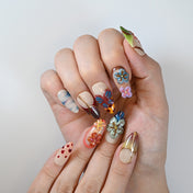Handmade floral and butterfly nails in bright tropical colors with gradient tips