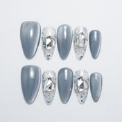 Frosty winter press-on nails with clear glitter tips and silver geometric embellishments