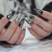Glam black and gold nails with 3D crystal gems, spider, and metallic crosses