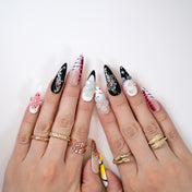 Bold long press-on nails featuring 3D floral designs, stripes, and gemstone accents