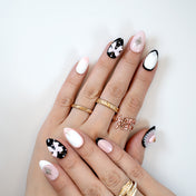 Chic handmade nails featuring black and pink contrast, pearls, and ribbon accents