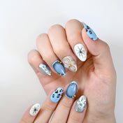 Fashion-forward blue and silver press-on nails with animal print and 3D gold flower