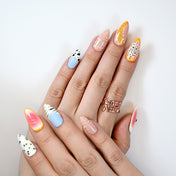 Color-block press-on nails with pastel blue, peach, yellow and pink fruit-inspired designs
