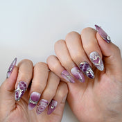 Galaxy-inspired purple chrome nails with rhinestones, heart art, and abstract swirls