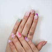 Spring press-on nails with pink 3D flowers, purple gradients, and pearl bow accents