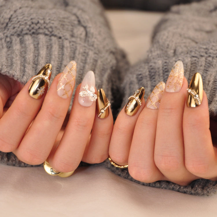 Luxury Christmas nails with gold glitter snowflakes, pearl details, and metallic finish