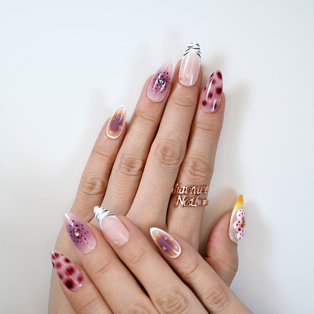  Luxury animal print nails with burgundy pattern, zebra tip accent, and floral embellishment