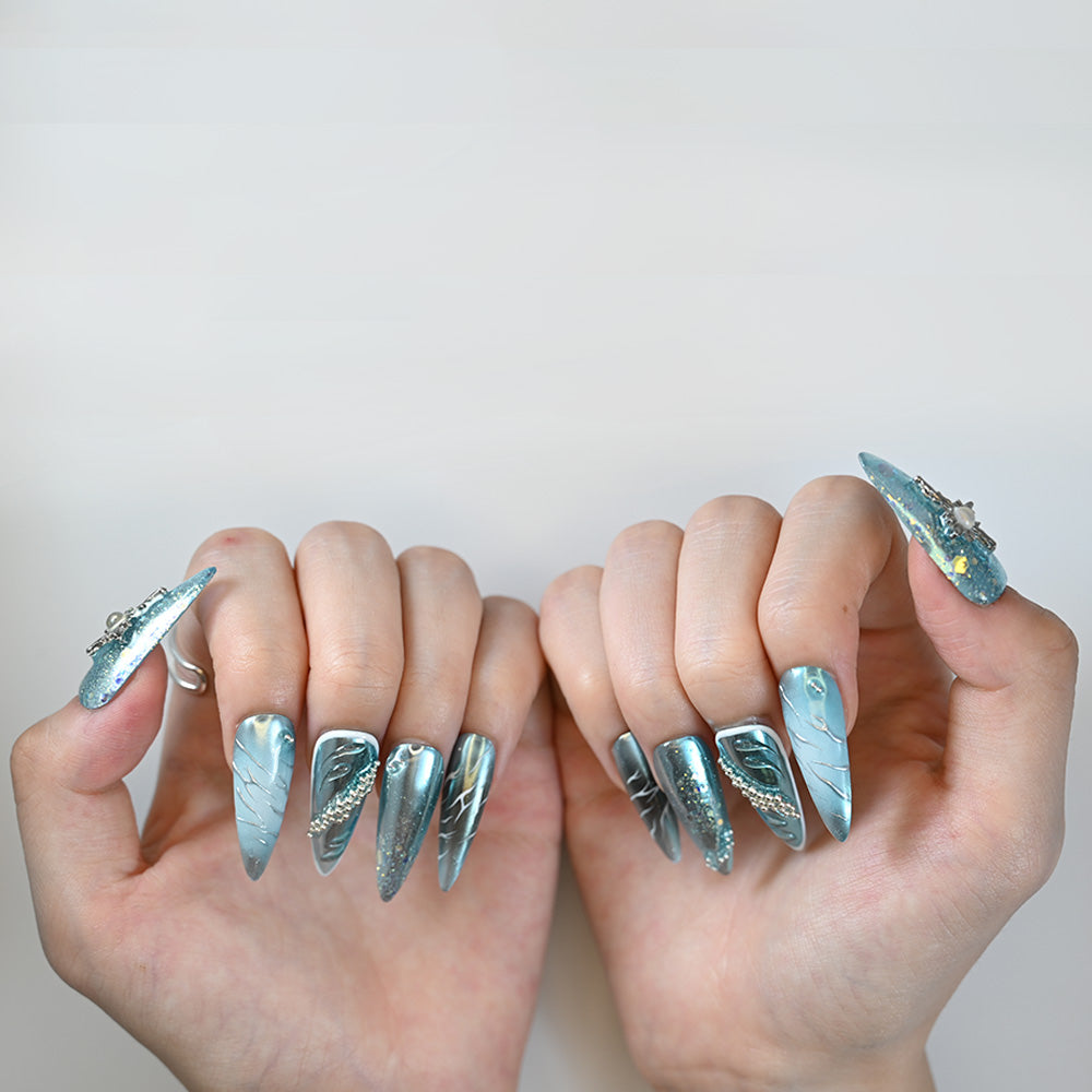 Elegant long stiletto blue nails featuring silver lines and crystal accents