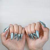 Elegant long stiletto blue nails featuring silver lines and crystal accents