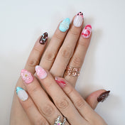 Playful almond nails with heart design, turquoise tips and fruity patterns