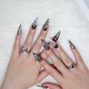 Handmade long stiletto nails with metallic marble effect and angel decorations