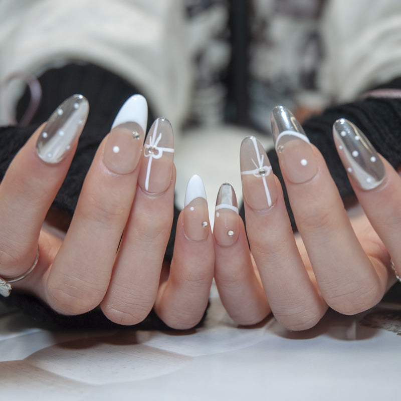 Elegant nude and chrome nails with rhinestone accents and ribbon art