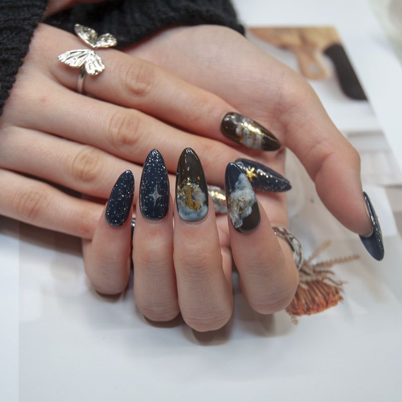 Handmade night sky nails with galaxy clouds, glitter, and metallic gold details
