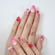 Cute pink and red handmade nails featuring berry texture and girly ribbon accents
