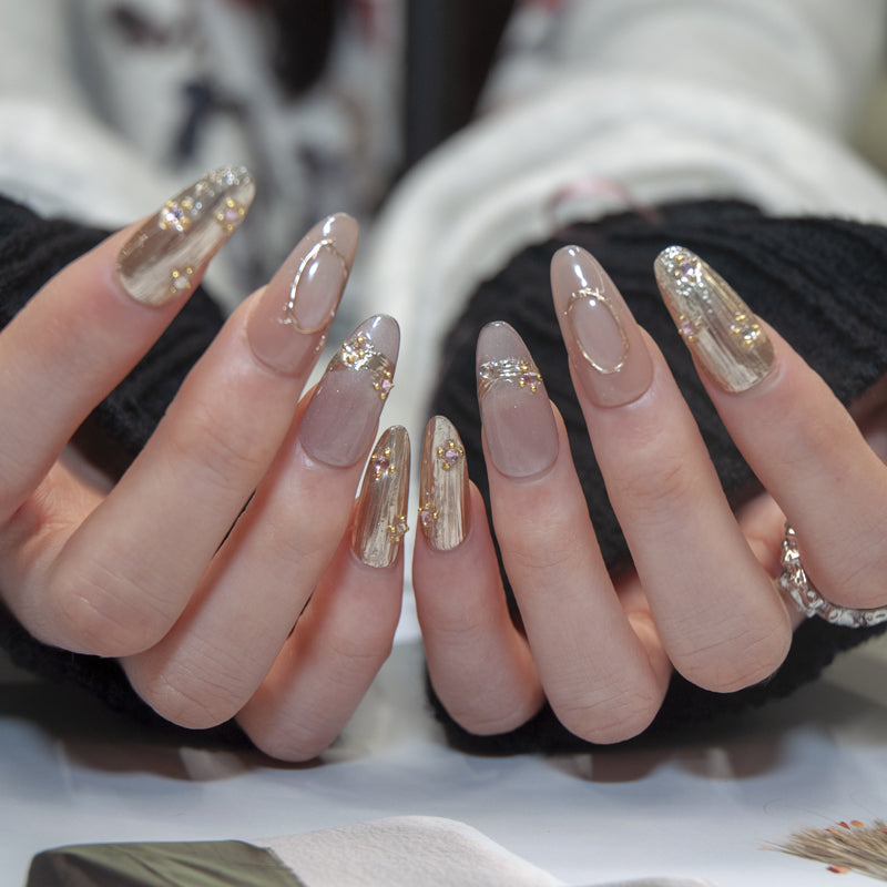 Luxury press-on nails with champagne gold texture and gemstone embellishments