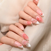 Romantic pink and white press-on nails featuring handmade floral art and pearl details