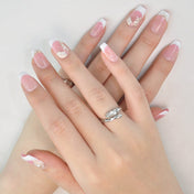 Handmade French tip nails with soft pink base, golden butterfly accents, and cute bow