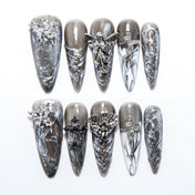 Gray and silver press-on nails with 3D angel charms and gothic cross accents