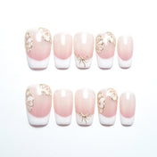 Short  coffin  press-on nails with pink and white French tips, 3D gold butterflies, and bow design